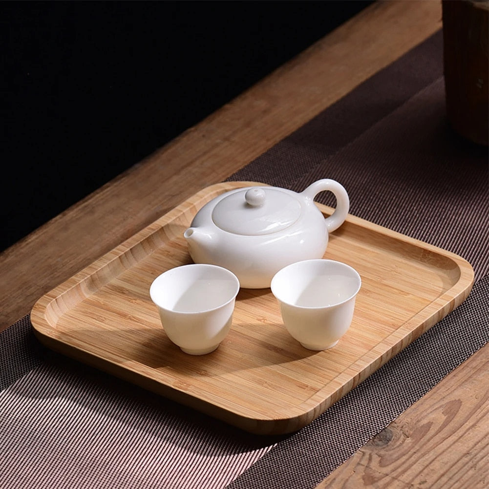 Square woven bamboo serving tray with slightly raised edges – shown in a room setting