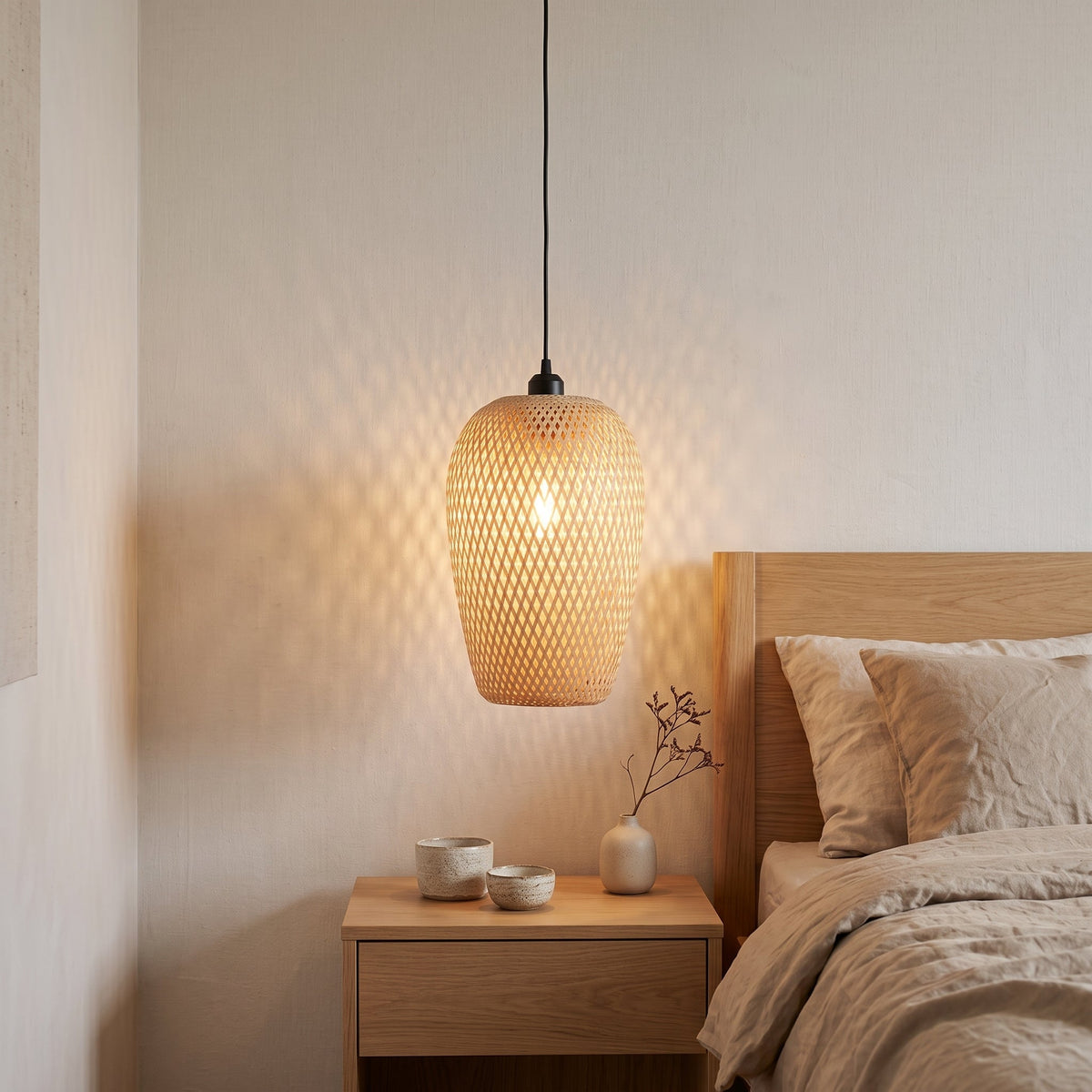 Oval woven bamboo bedside pendant light – shown in a room setting