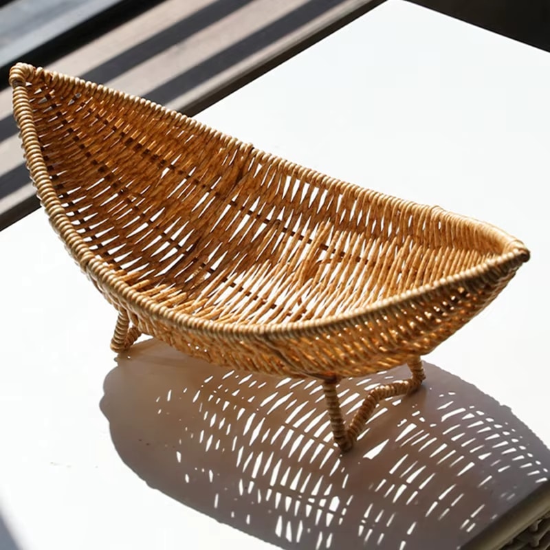 Handwoven natural rattan banana-shaped basket – shown in a room setting