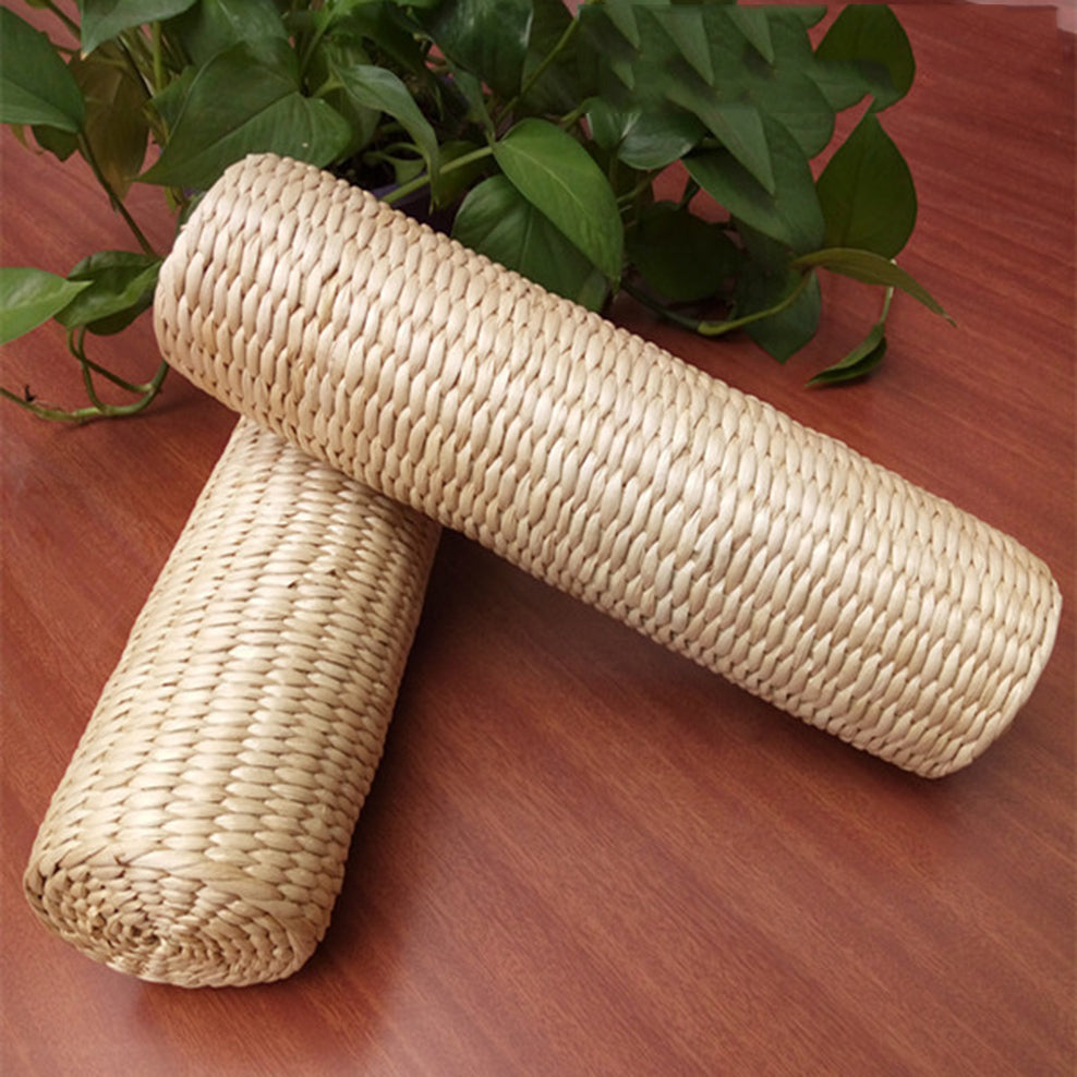 Cylindrical light rattan bolster pillow – shown in a room setting