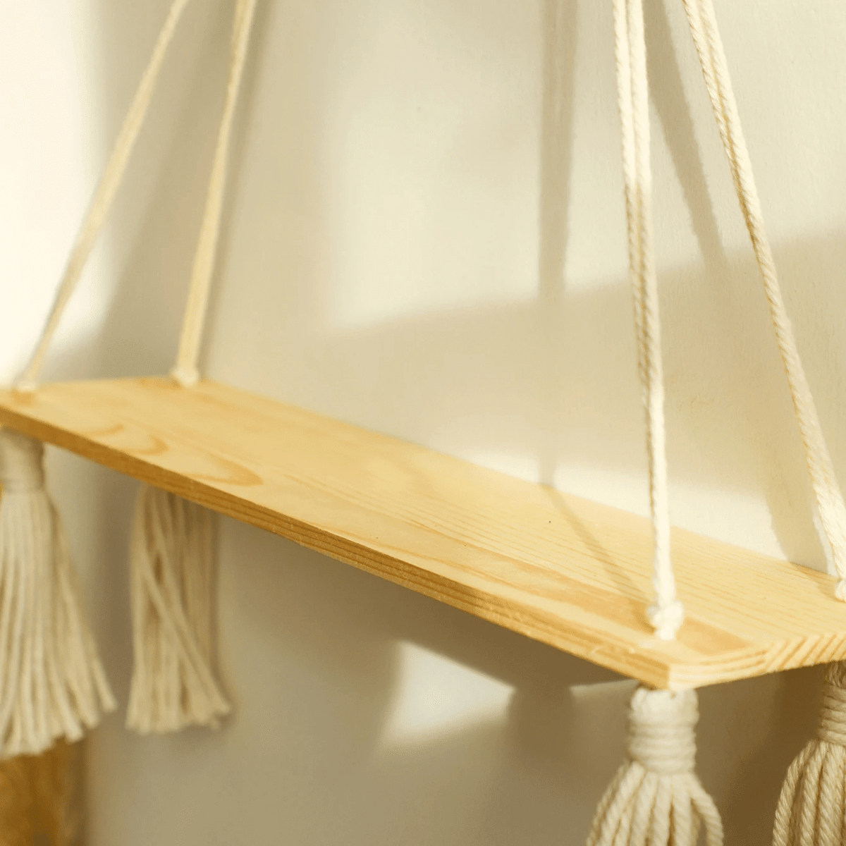 Boho hanging wood shelf suspended by hand-knotted macramé – close-up detail