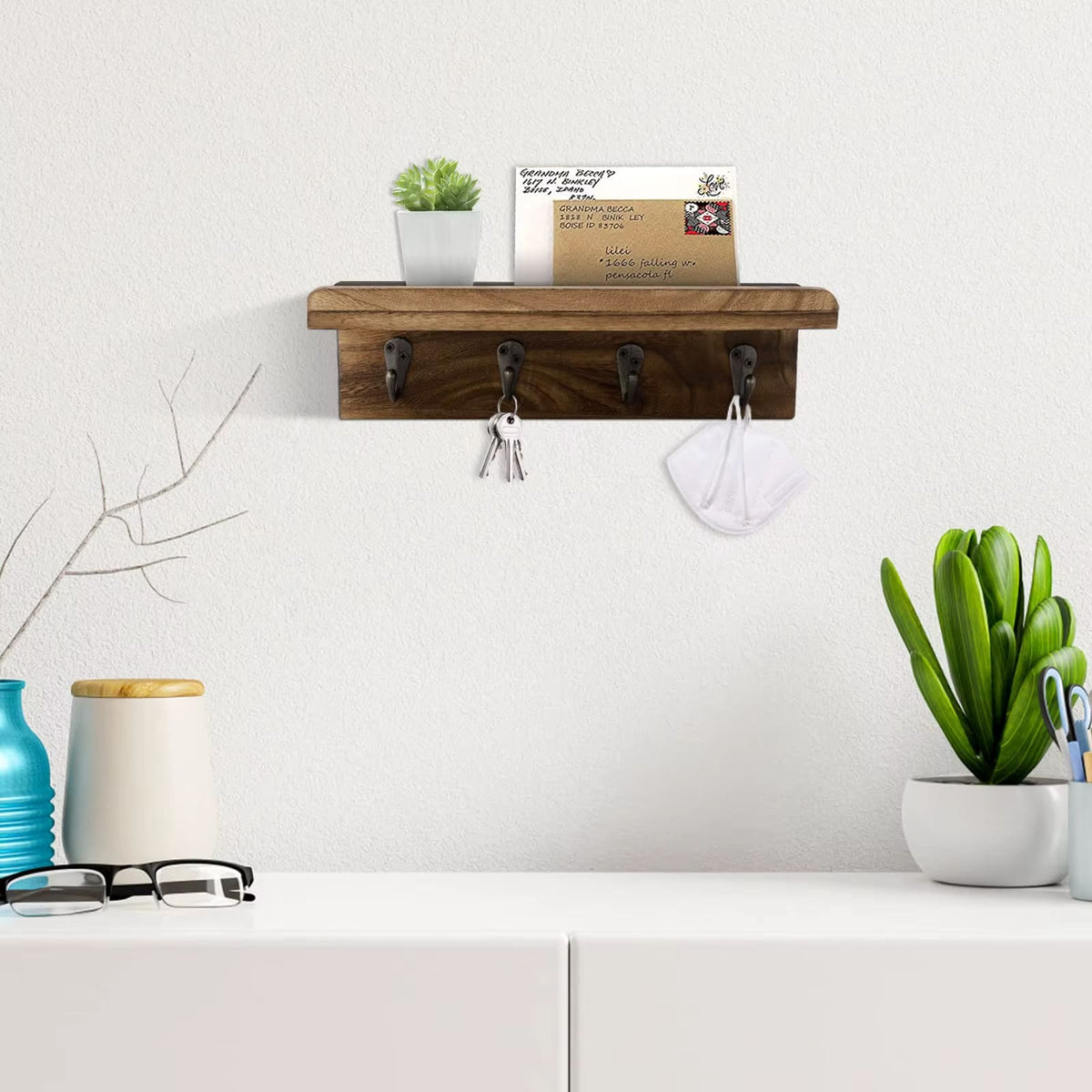 Wooden wall key holder with a floating shelf and four hooks – shown in a room setting (3)