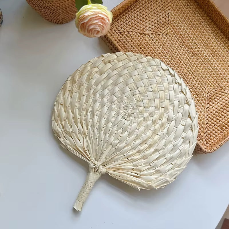 Retro half-circle rattan fan with a knotted handle – shown in a room setting