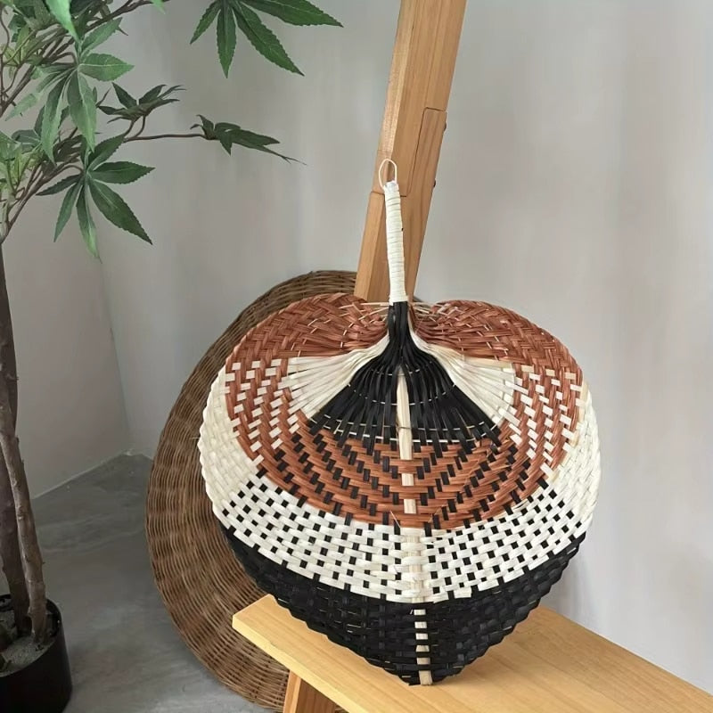 Braided raw rattan fan mounted on a slim stick – shown in a room setting (2)