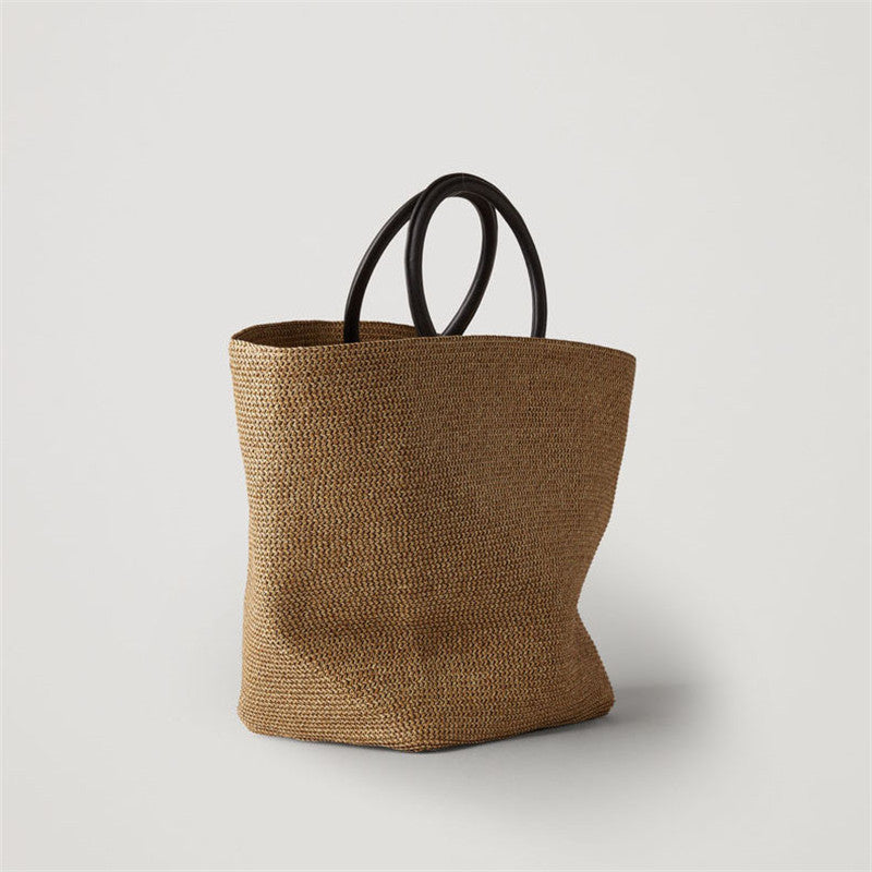 Large oval rattan handbag with a leather handle and bamboo clasp