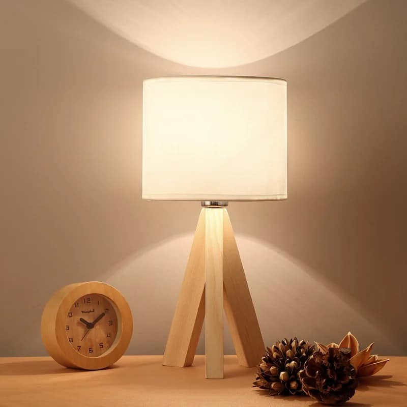 Contemporary natural wood bedside lamp with a handwoven shade – shown lit