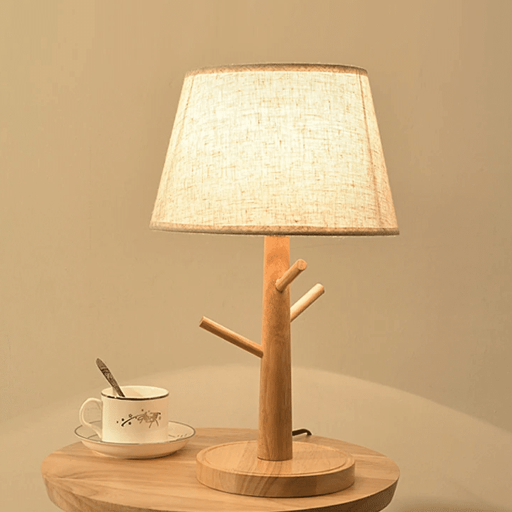 Natural wood LED bedside lamp with a fabric shade – shown lit