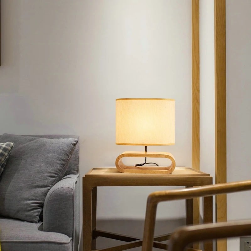 Rounded handwoven rattan bedside lamp in natural tones – shown in a room setting