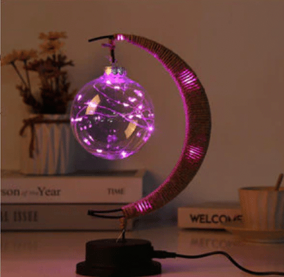 Woven hemp crescent moon lamp with a blush pink globe – shown lit