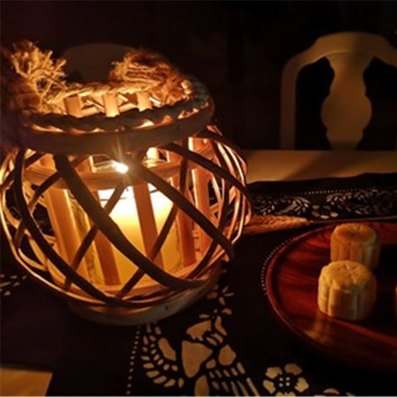 Square retro rattan lantern with spiral woven rope – shown lit in a room setting (2)