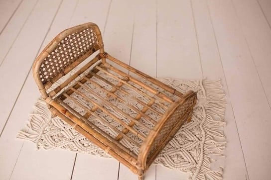 Braided rattan baby bed – beige variant, shown in a room setting