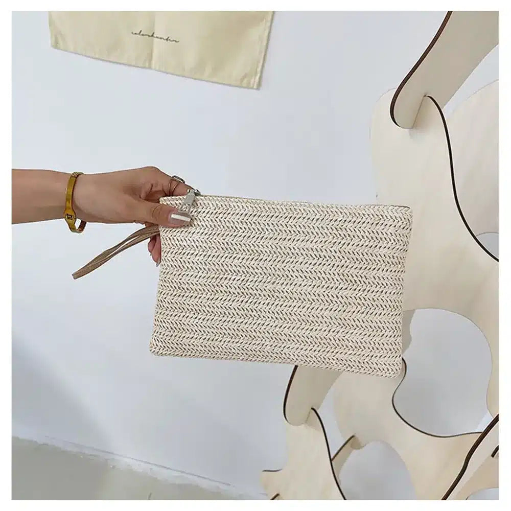 Woven rattan clutch with a brown strap – worn by a model (3)