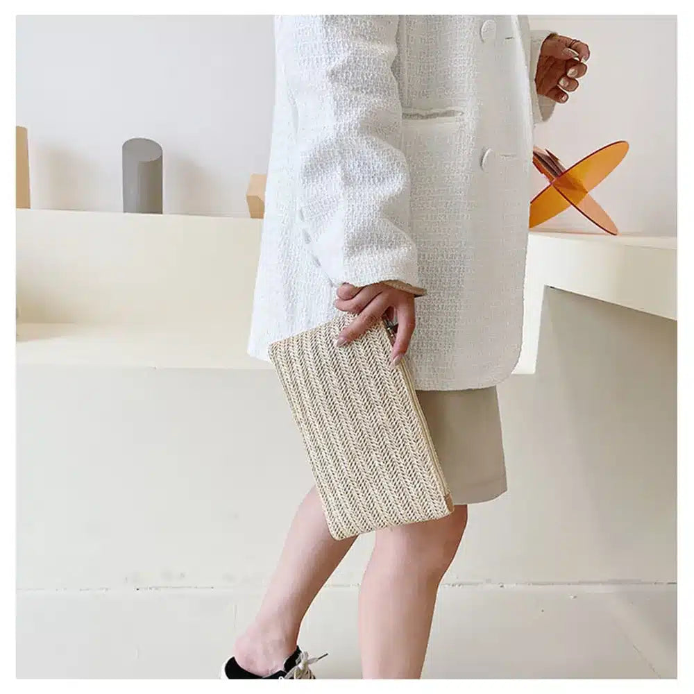Woven rattan clutch with a brown strap – worn by a model (2)