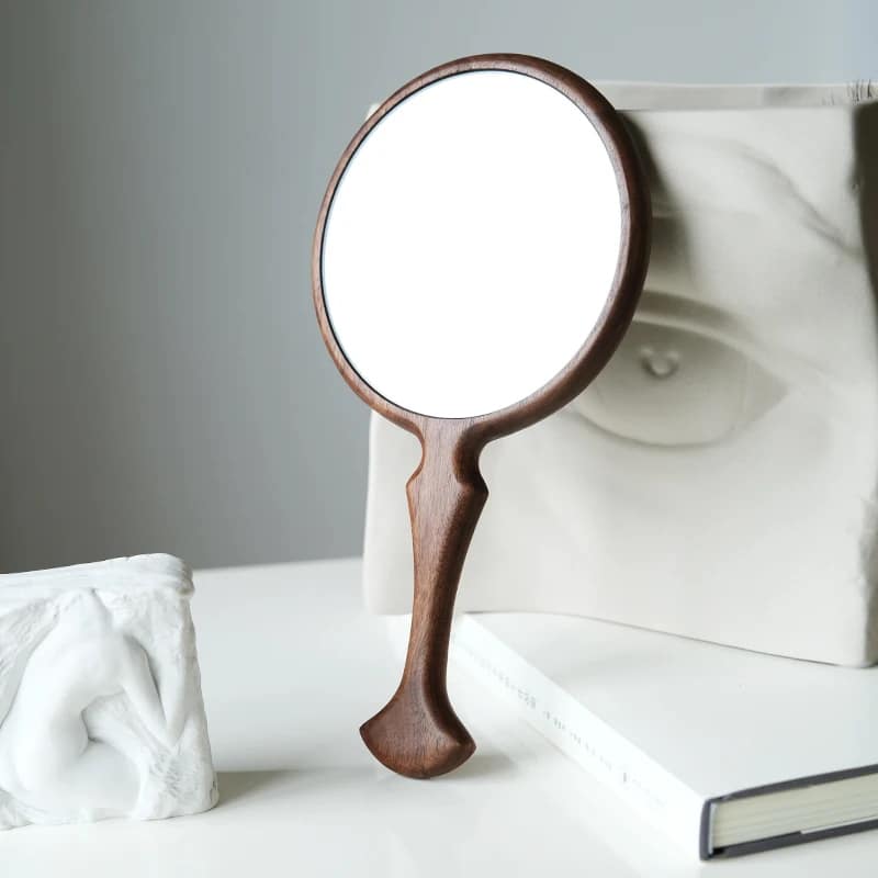 Round retro wooden hand mirror with a braided handle – shown in a room setting