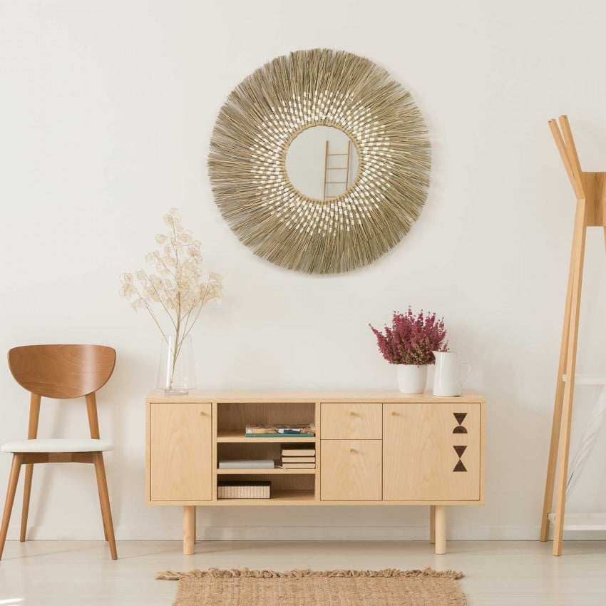 Boho round rattan wall mirror with an interlaced frame – shown in a room setting