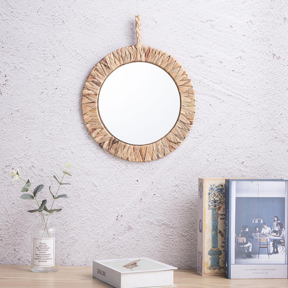 Natural rattan sun mirror with rays radiating from a circular frame – shown in a room setting