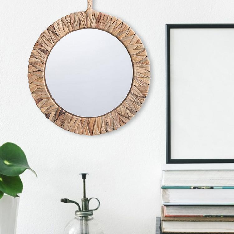 Natural rattan sun mirror with rays radiating from a circular frame – shown in a room setting (2)
