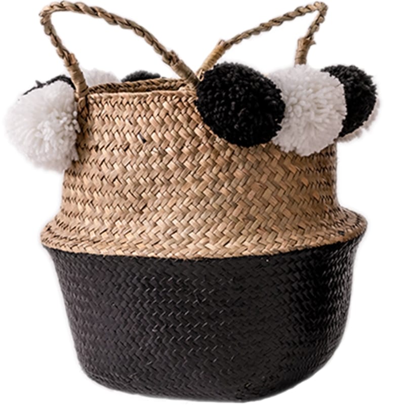 Black rattan basket with braided handles and black-and-white pompoms