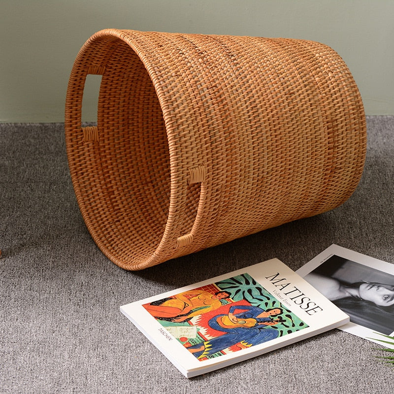 Structured natural rattan laundry hamper with two side handles – shown in a room setting (2)