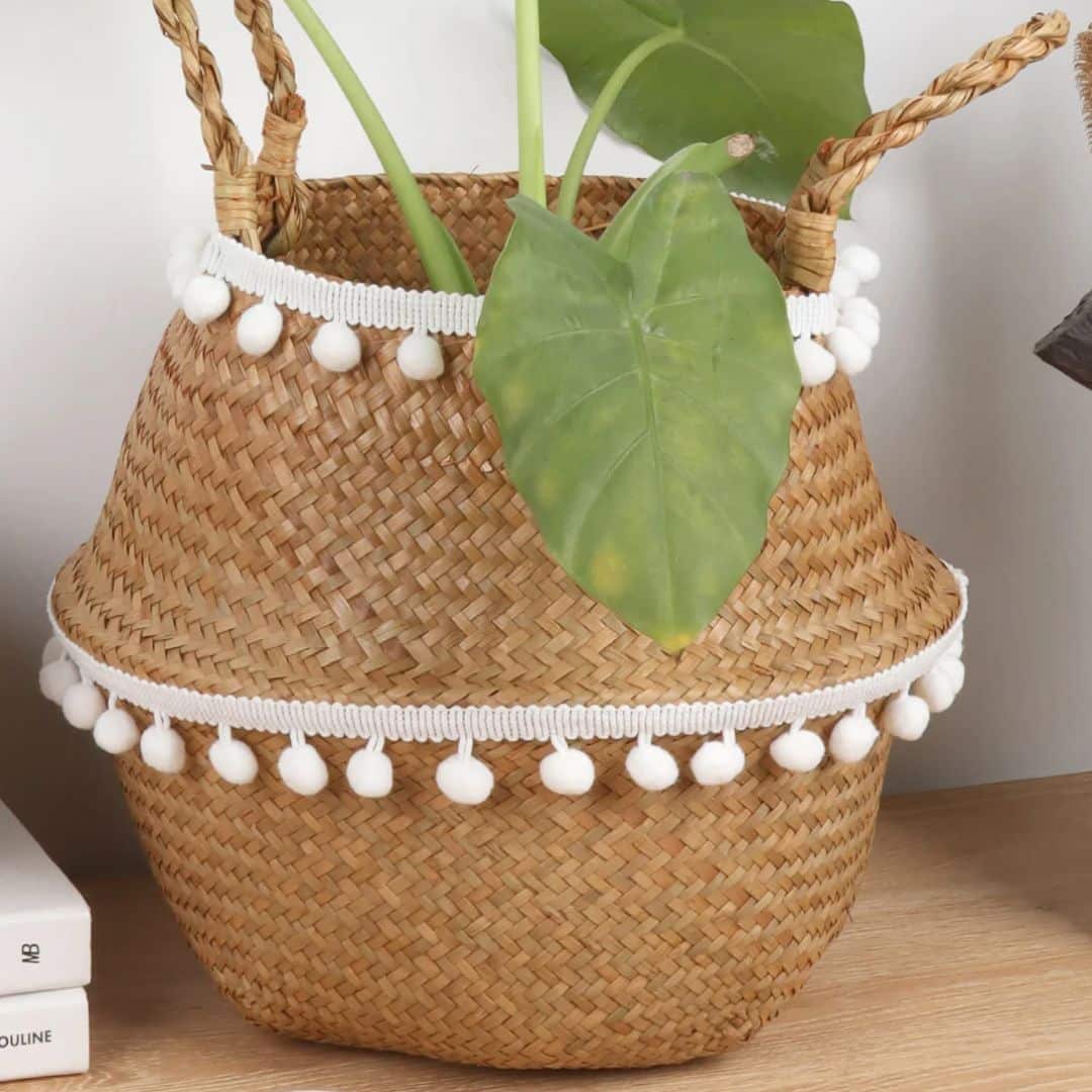 Round rattan basket with hand-knotted tassels – shown in a room setting