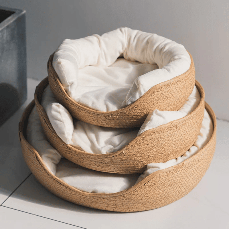 Round rattan pet bed with a flat cushion and bolster – multiple views