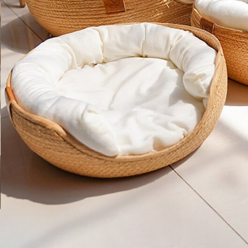 Round rattan pet bed with a flat cushion and bolster