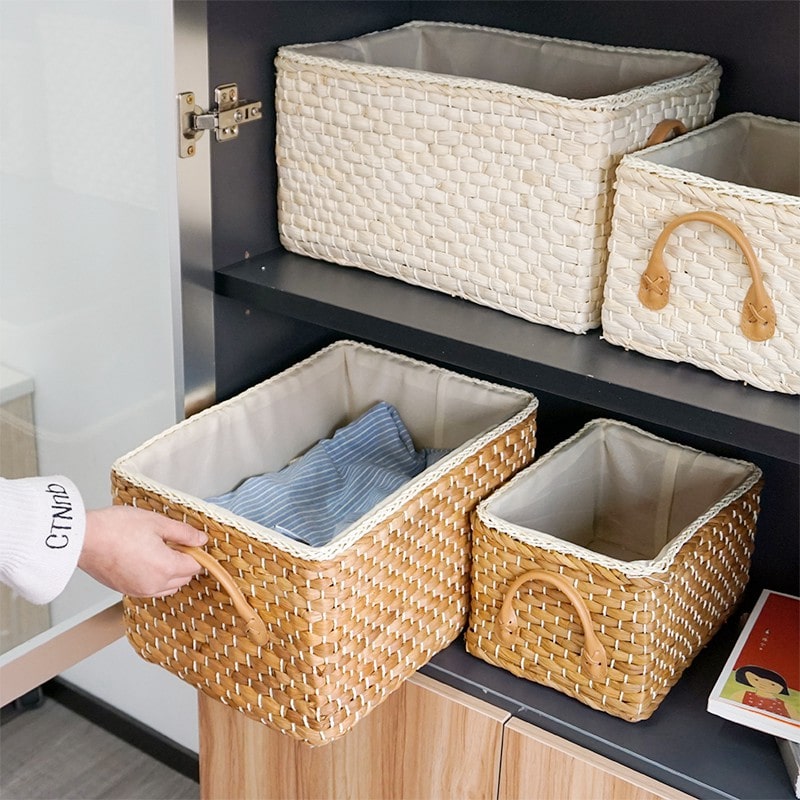 Handwoven wicker storage basket with two handles – shown in a room setting (2)