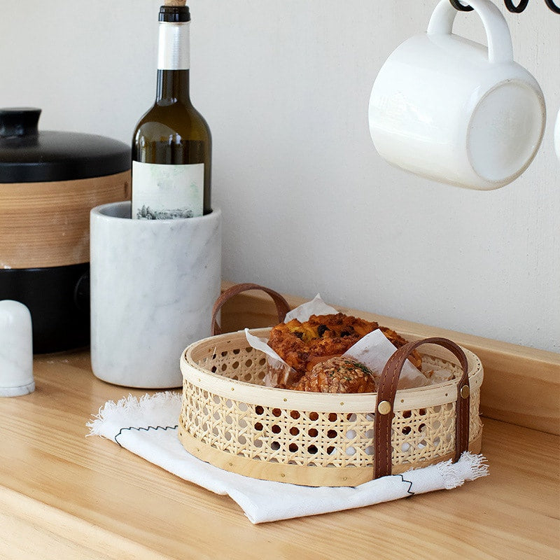 Brown handwoven rattan storage basket – shown in a room setting (2)