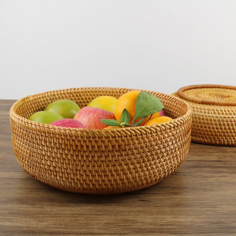 Round woven storage basket in natural rattan and plant fibers – shown in a room setting