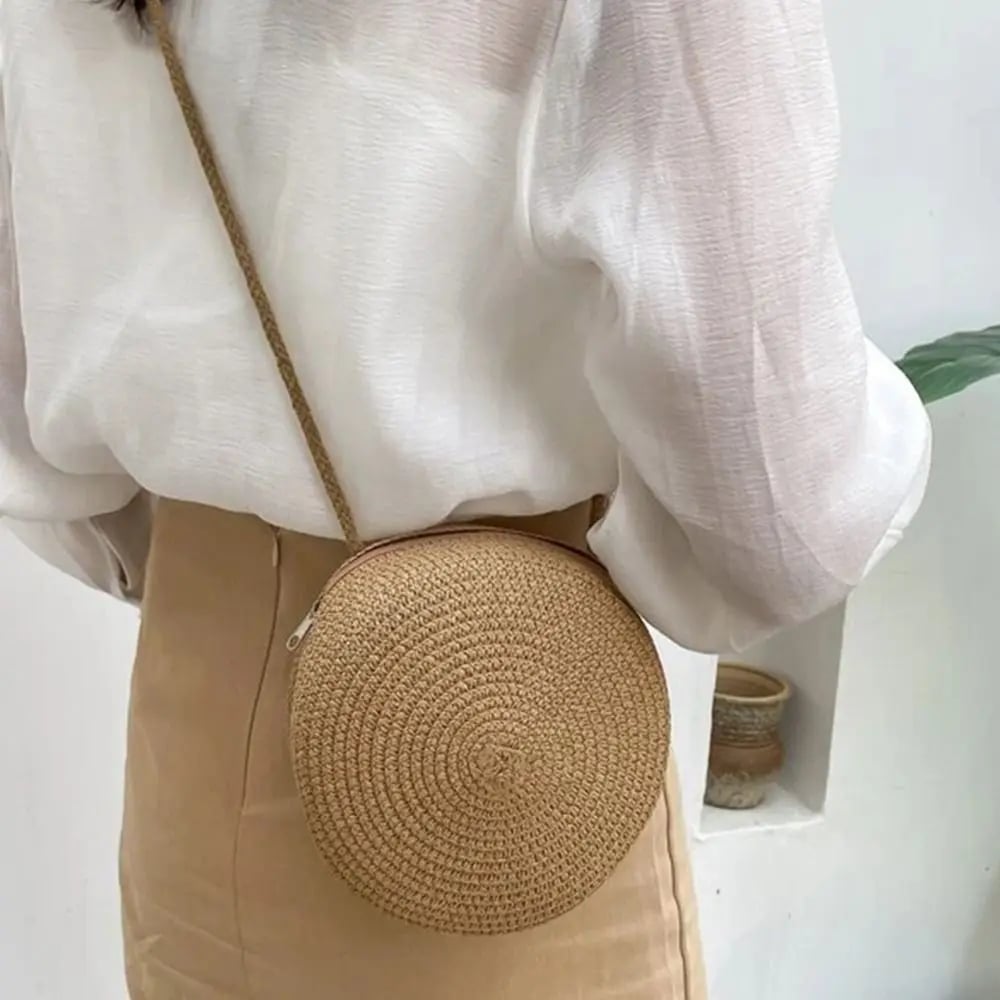 Round brown wicker-look crossbody basket bag – worn by a model