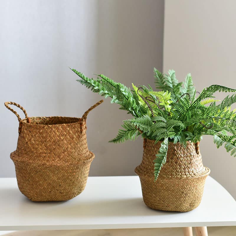 Round handwoven rattan planter basket hiding a plant pot – shown in a room setting