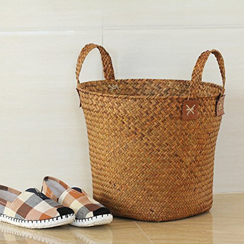 Round handmade natural straw basket with handles – shown in a room setting