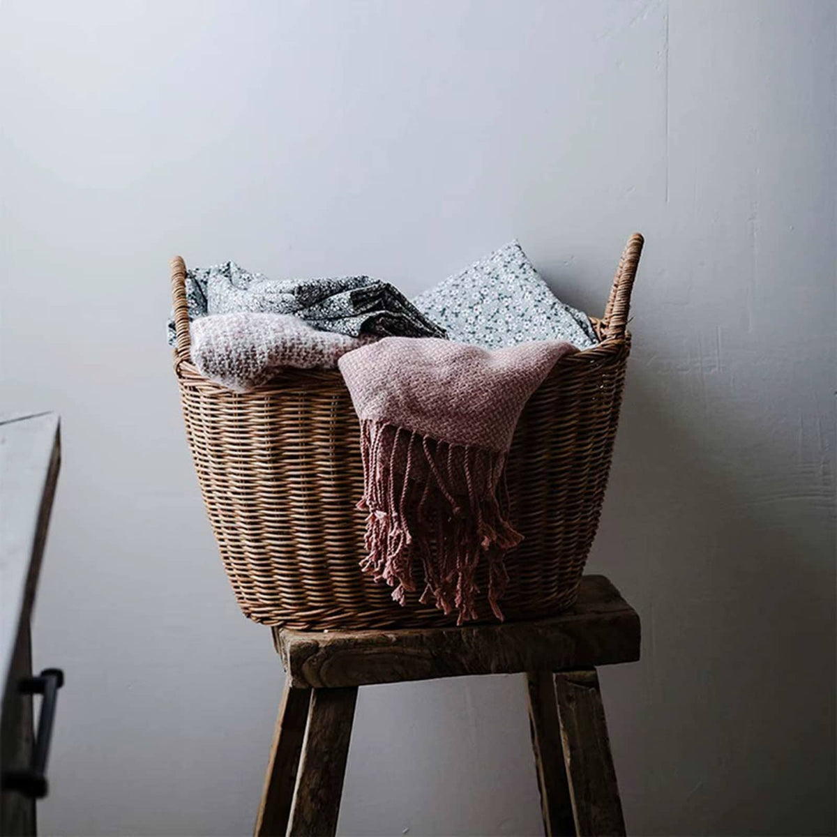 Sturdy vintage rattan laundry basket with a flared, ribbed silhouette – shown in a room setting (2)