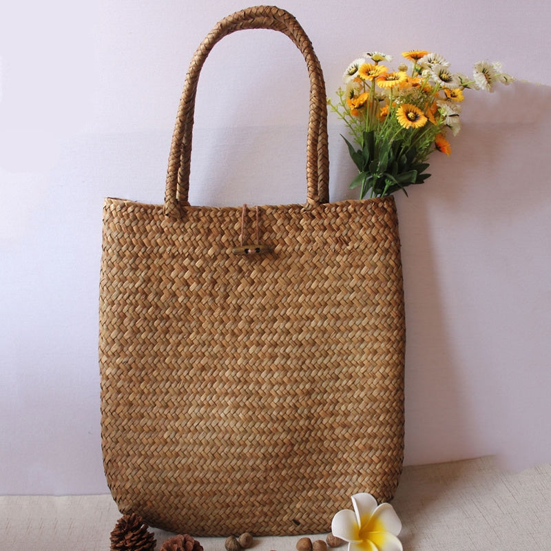 Handmade rattan shoulder basket bag with an adjustable strap – shown in a room setting