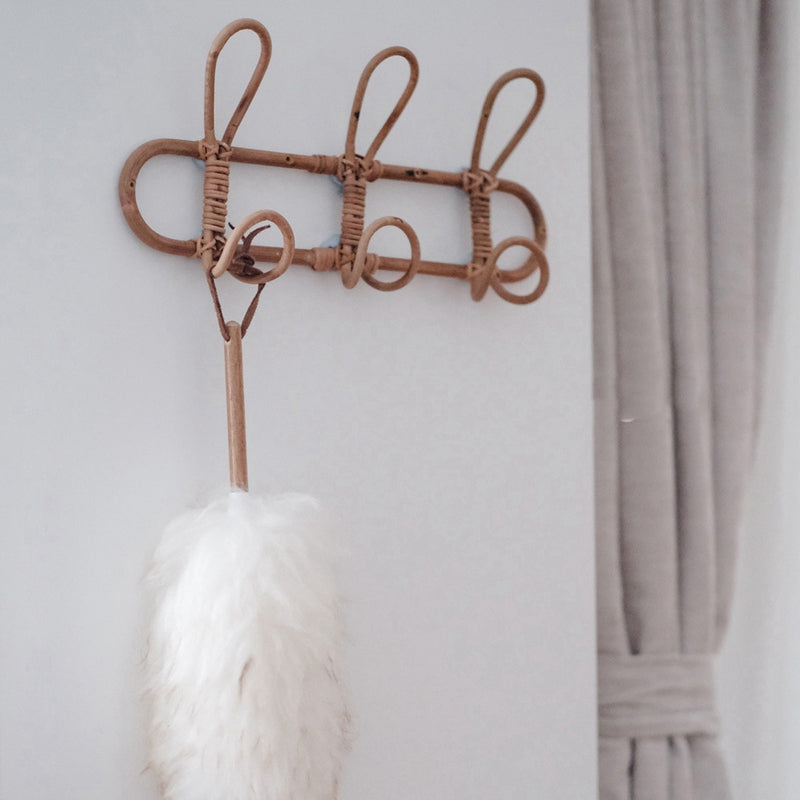 Dark rattan round wall rack with three hooks – shown in a room setting