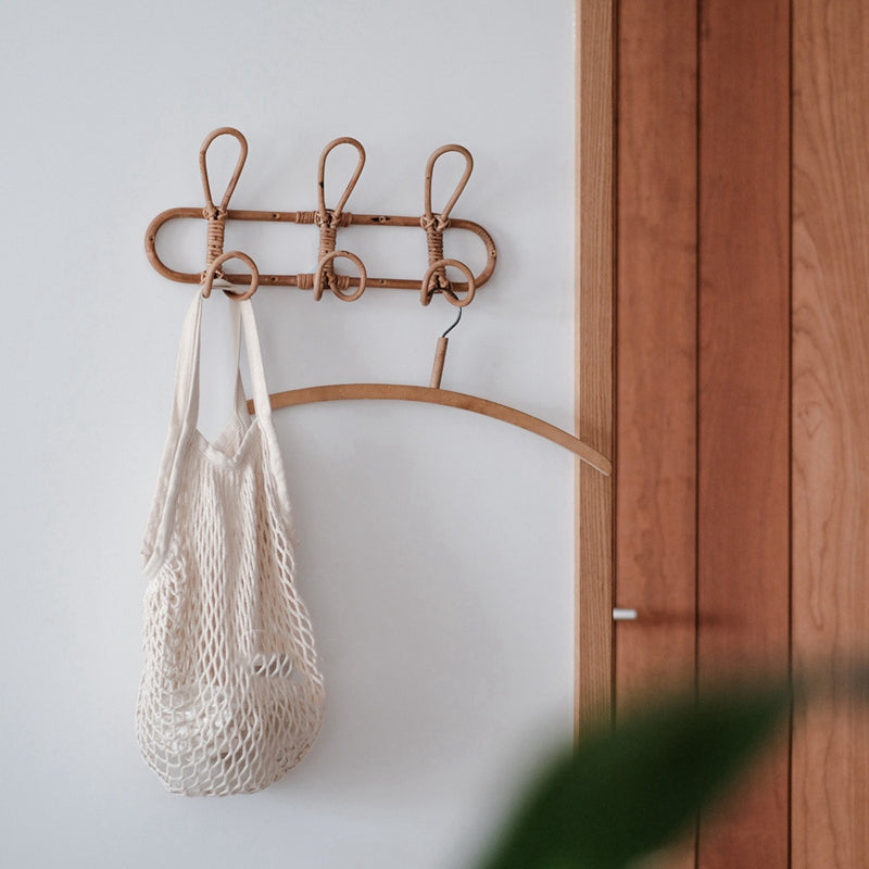 Dark rattan round wall rack with three hooks – shown in a room setting (4)