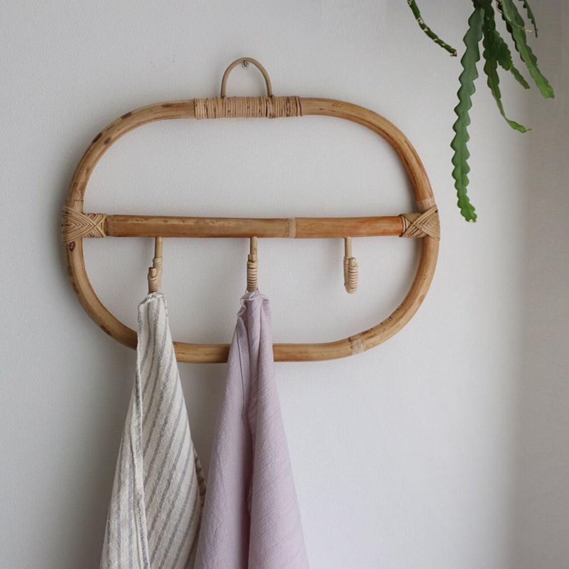 Rectangular natural rattan coat rack with three braided hooks – shown in a room setting (2)