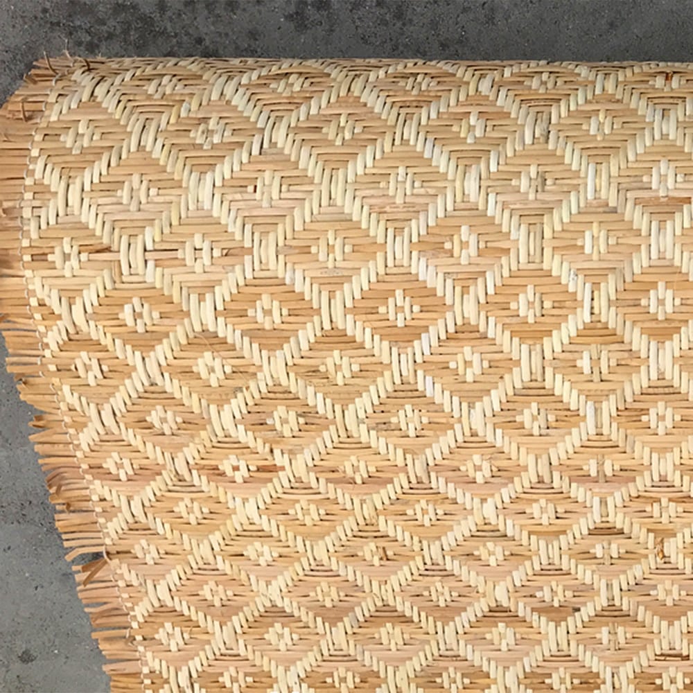 Natural woven rattan cane panel with golden fibers – close-up detail