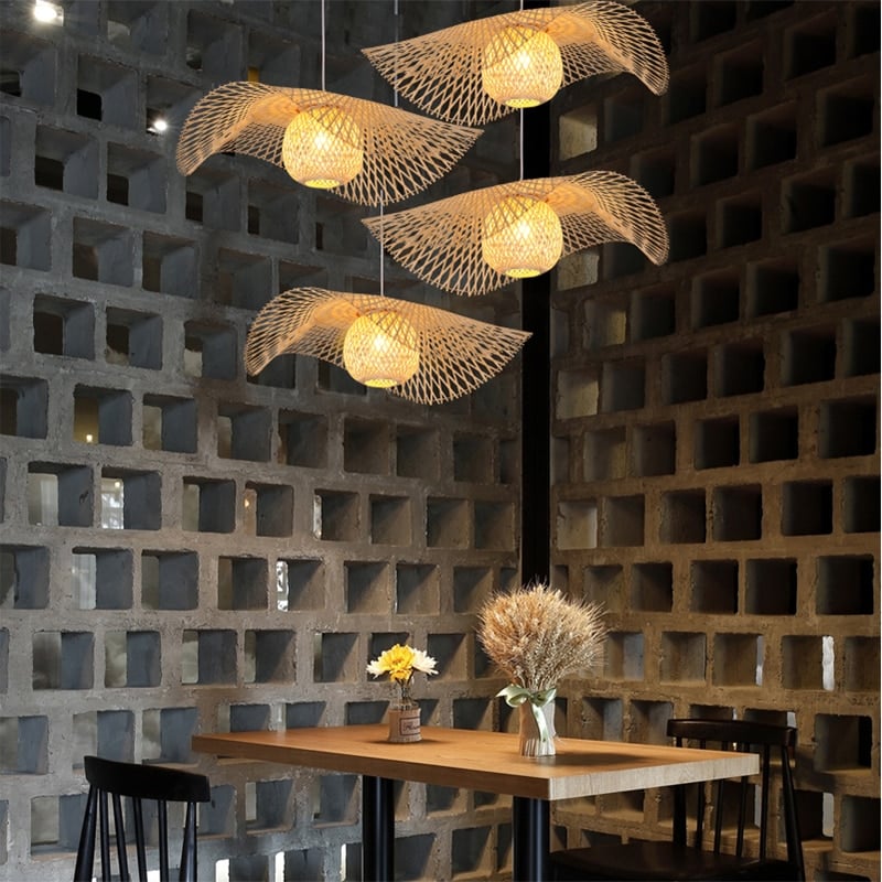 Tropical handwoven rattan ceiling light with a circular weave – shown lit in a room setting