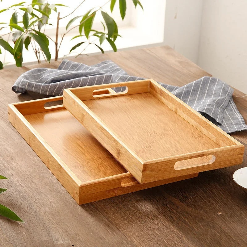 Rectangular bamboo tray with handles and a smooth golden surface – shown in a room setting