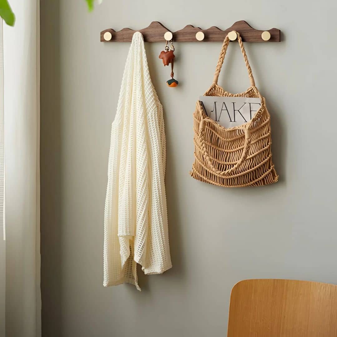 Wooden wall coat rack with gold-finish hooks – shown in a room setting