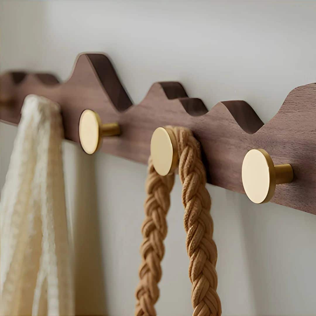 Wooden wall coat rack with gold-finish hooks – shown in a room setting (2)