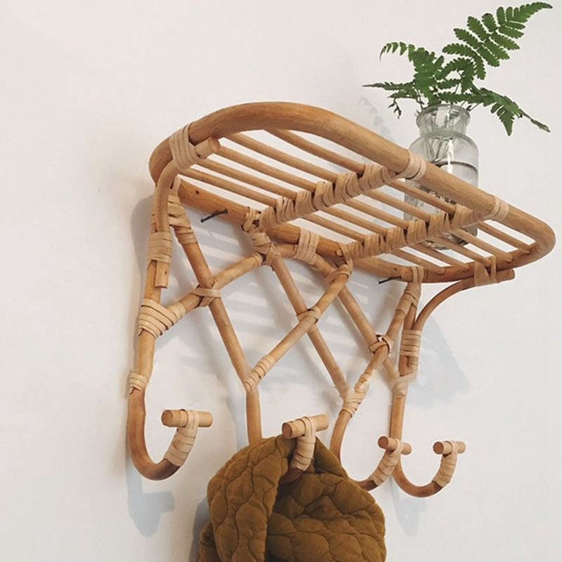 Crossed rattan wall coat rack with a top shelf and four hooks – shown in a room setting