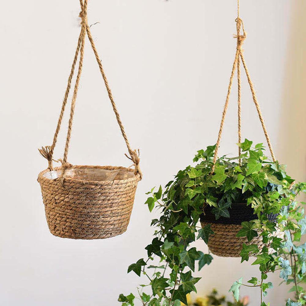 Hanging natural rattan plant holder with a round frame and fringes – shown in a room setting (3)