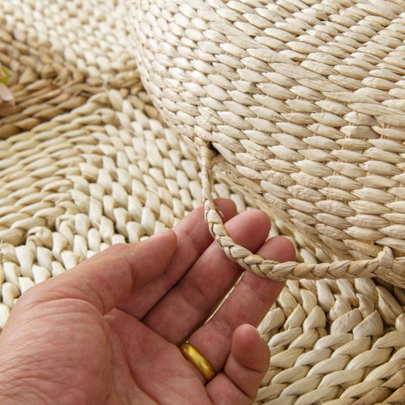 Light rattan pouf with a built-in handle – shown in use