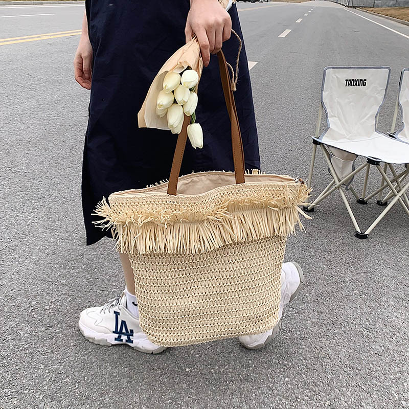 Large white straw crossbody bag with fringe trim – worn by a model (3)
