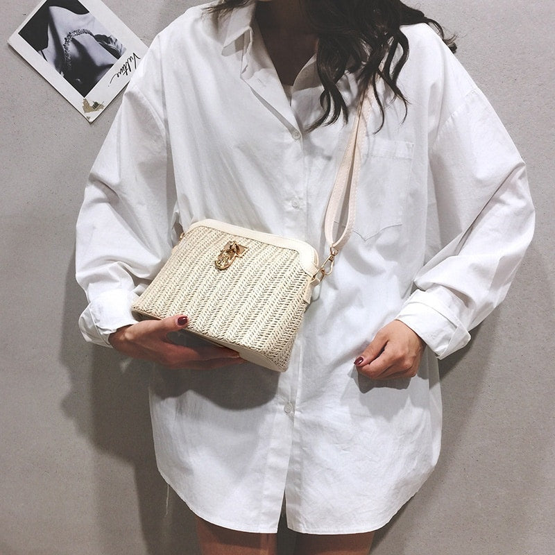 Beige rattan beach bag with gold chain handles – worn by a model
