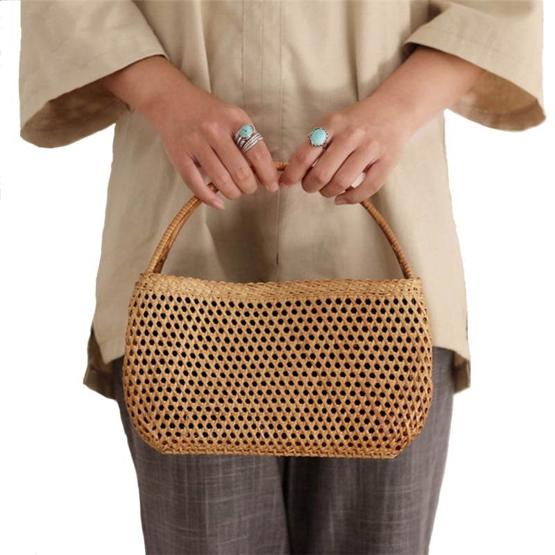 Honey rattan handbag with varnished wooden handles – worn by a model