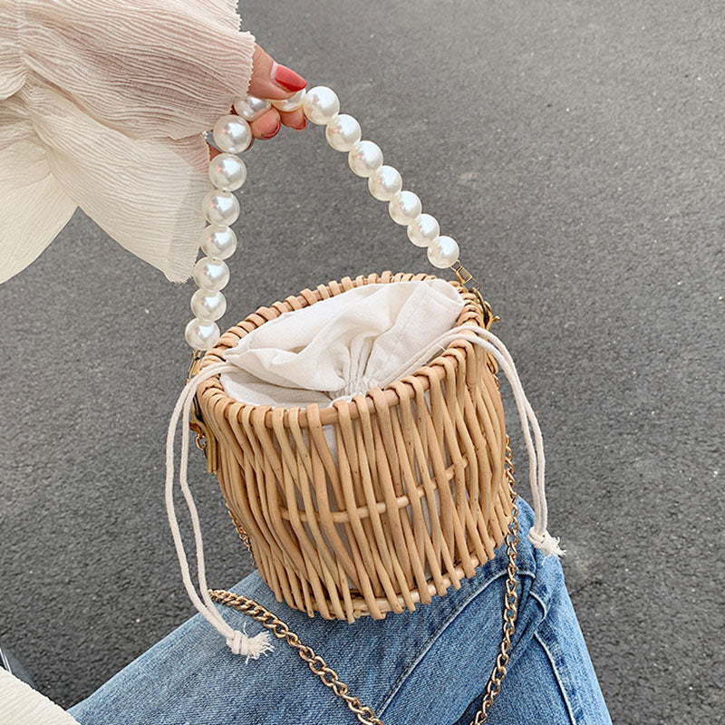 Round basket-shaped rattan handbag with a soft handle – worn by a model