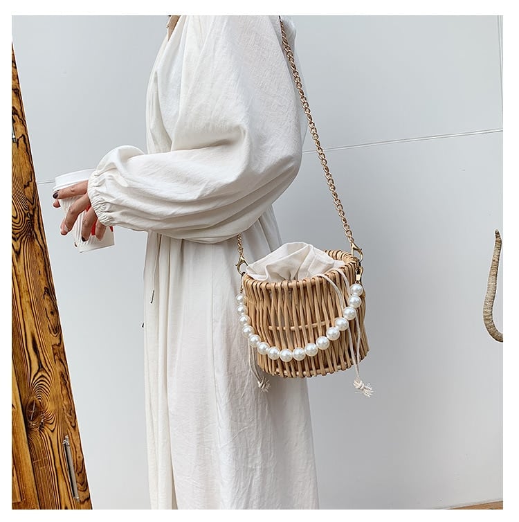 Round basket-shaped rattan handbag with a soft handle – worn by a model (2)